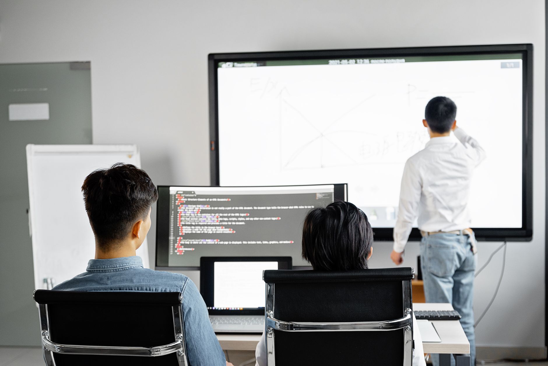 Programiści omawiający wdrożenie strony przy ekranie