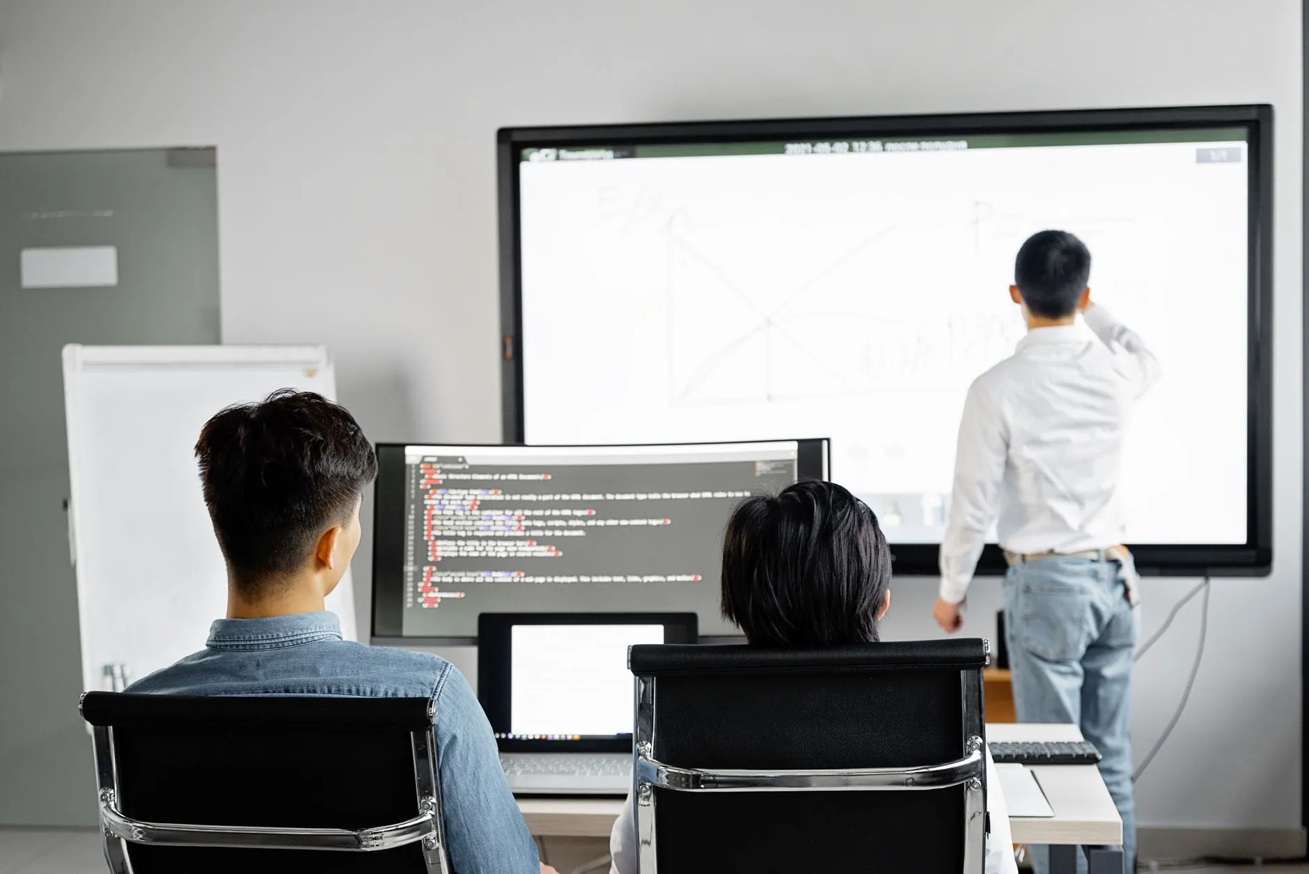 Programiści omawiający wdrożenie strony przy ekranie